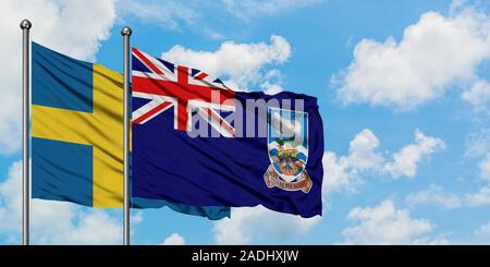 La Svezia e nelle Isole Falkland bandiera sventolare nel vento contro bianco torbido cielo blu insieme. Concetto di Diplomazia e relazioni internazionali. Foto Stock