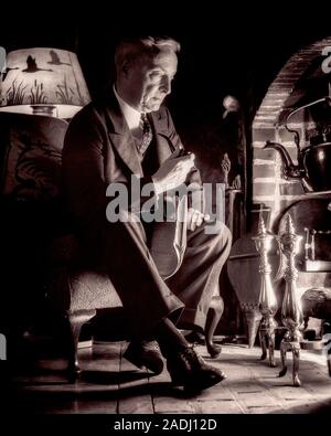 1920s uomo senior fumatori di ritegno del tubo di seduta di giornale prima di camino Guardando negli occhi la luce sognare pensare - f935 HAR001 HARS maschi guardando il pensionamento serenità spiritualità senior uomo adulto SENIOR B&W indossare giacca e cravatta PRIMA DI SOGNI VECCHIAIA OLDSTERS ANTICA TUBI DI SVAGO tabacco sognando il drammatico basso angolo pensare riflettente che riflette gli anziani meditare ponderando Connection considera perso nel pensiero concettuale fuga contemplazione immaginazione contemplativa ed elegante di fronte a meditare le idee di rilassamento meditativo in bianco e nero di etnia caucasica considerando HAR001 in vecchio stile Foto Stock