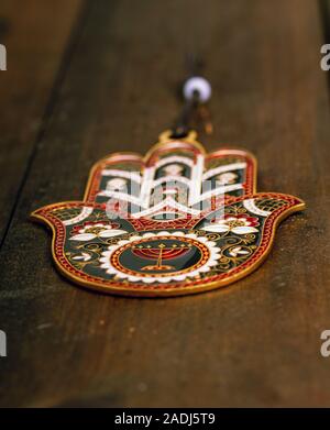 Amuleto protettivo Hamsa Fatima mano con un bel disegno appeso su una ruvida porta in legno Foto Stock