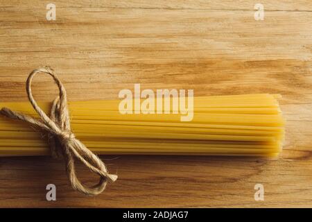 Spaghetti mazzetto orizzontale sulla superficie di legno Foto Stock