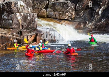 Gruppo di adolescenti formazione in kayak sul fiume Etive Falls, Glencoe, Highlands scozzesi, Scotland, Regno Unito in Marzo Foto Stock