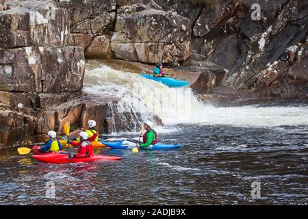 Gruppo di adolescenti formazione in kayak sul fiume Etive Falls, Glencoe, Highlands scozzesi, Scotland, Regno Unito in Marzo Foto Stock