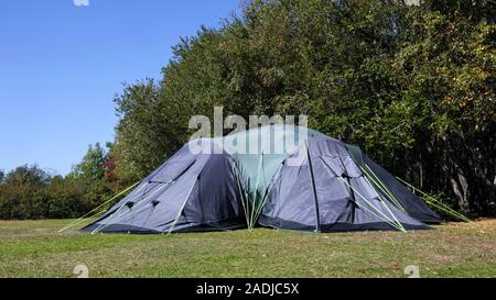La famiglia grande tenda da campeggio sul bordo del prato nella foresta campeggio su un estate giornata di sole Foto Stock