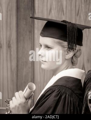 1930s GIOVANE DONNA IN POSSESSO DI UN DIPLOMA DI LAUREA che indossa il cappello e camice - S4431 HAR001 HARS STUDIO SHOT SPAZIO COPIA LADIES pensieroso persone premurose rischio laurea B&W la libertà delle scuole gli obiettivi di successo di testa e spalle forza università CORAGGIO E CONOSCENZA forte progresso realizzazione pensare riflettente Orgoglio alta scuola umore riflettendo alte scuole di istruzione superiore meditare ponderando considera perso nel pensiero concettuale adolescente elegante collegi meditare contemplativa MORTARBOARD MEDITATIVA ADULTO GIOVANE DONNA IN BIANCO E NERO il cappello e abito di etnia caucasica considerando HAR001 in vecchio stile Foto Stock