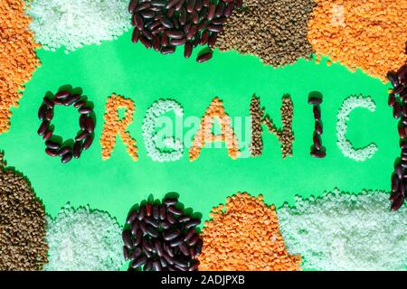Telaio di diversi cereali con parola organico su sfondo verde. Parola organico fatto di grano vari. Mix di cereali e fagioli. Alimenti biologici. Foto Stock