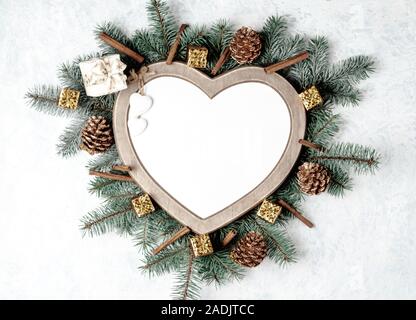 Scheda di Natale, cornice a forma di cuore, con decorazioni di Natale. Foto Stock