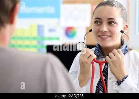 Graziosa infermiera sorridente andando ad ascoltare indietro Foto Stock