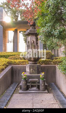 Sei statue di Jizo su un memoriale esagonale stone stand dove è inciso in ideogrammi giapponesi spirito del reame la realtà con due vasi ornati con Foto Stock