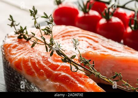 Il ramo di timo posto sulla fetta di crudo di pesce rosso Foto Stock