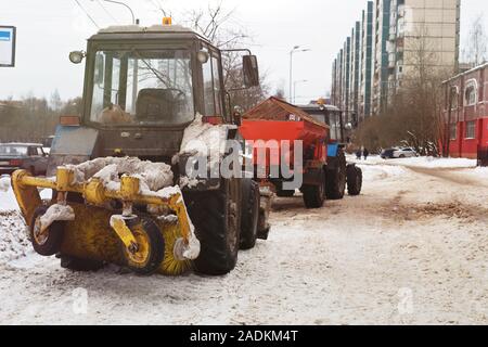 Rimozione della neve in città e la trasformazione di marciapiedi agente contro il ghiaccio Foto Stock