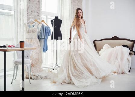 Bella bionda. Il processo di montaggio del vestito in studio di lavorati a mano i vestiti Foto Stock