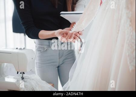Lavori in corso. Il processo di montaggio del vestito in studio di lavorati a mano i vestiti Foto Stock