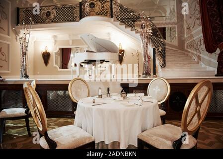 Accogliente atmosfera romantica. Interno del ristorante di lusso in vintage stile aristocratico con pianoforte sul palco Foto Stock
