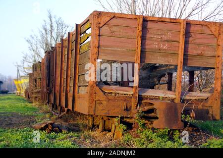 Vecchio treno dimenticato sulle piste. Un arrugginito e danni di trasporto carro ferroviario. Foto Stock