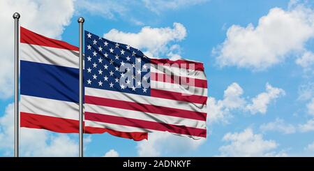 La Tailandia e gli Stati Uniti bandiera sventolare nel vento contro bianco torbido cielo blu insieme. Concetto di Diplomazia e relazioni internazionali. Foto Stock