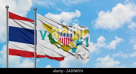 La Tailandia e gli Stati Uniti Isole Vergini bandiera sventolare nel vento contro bianco torbido cielo blu insieme. Concetto di Diplomazia e relazioni internazionali. Foto Stock