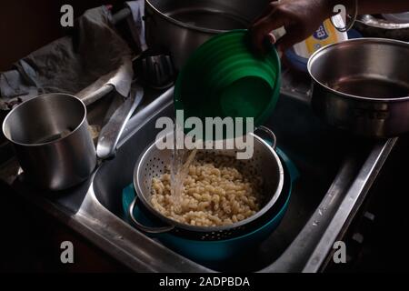 Caracas, Miranda, Venezuela. 29 Nov, 2019. Aura cuoce la pasta per la cena per suo figlio e suo marito Jose con l'acqua raccolta. Aura Graciela Sarmiento, di anni 56, e suo marito Jose Alberto Abreu, 62 anni, non hanno avuto e non hanno acqua corrente a casa loro in 4 anni. Aura lavora in un negozio di vendita di mobili per ufficio e Jose è un meccanico. Essi vivono nel quartiere di Altos de Lidice in Caracas Venezuela. Altos de Lidice è uno storico quartiere Chavista. Tuttavia, Aura è pro-opposizione, e non ha mai sostenuto il regime di Chavez anche se lei ha vissuto in questo pro-Chavez/Maduro barrio la sua wh Foto Stock