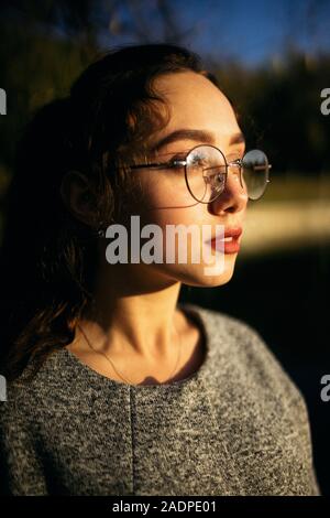 Profilo ritratto di una giovane donna in un cappotto grigio Foto Stock