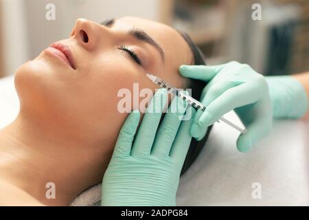 Close up del processo di iniezione di acido ialuronico Foto Stock