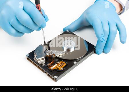 Gli uomini con le mani in mano in guanti blu riparazione smontaggio del disco rigido. La manutenzione del computer, il concetto di tecnologia Foto Stock