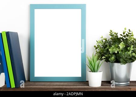 Poster interni mock up verticale con telaio in legno, libri e casa di piante su muro bianco sullo sfondo Foto Stock