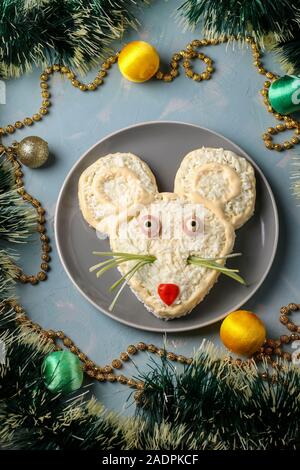 Insalata di festosa Mouse per il 2020 su fondo azzurro, un alimento simbolico per il nuovo anno, vista dall'alto, con orientamento verticale Foto Stock