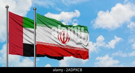 Emirati Arabi Uniti e l'Iran bandiera sventolare nel vento contro bianco torbido cielo blu insieme. Concetto di Diplomazia e relazioni internazionali. Foto Stock