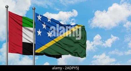 Emirati Arabi Uniti e Isole Salomone bandiera sventolare nel vento contro bianco torbido cielo blu insieme. Concetto di Diplomazia e relazioni internazionali. Foto Stock