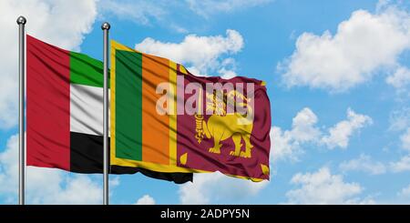 Emirati arabi uniti e lo Sri Lanka bandiera sventolare nel vento contro bianco torbido cielo blu insieme. Concetto di Diplomazia e relazioni internazionali. Foto Stock