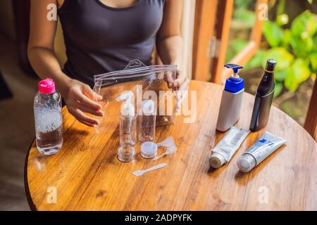 Kit da viaggio per il trasporto di prodotti cosmetici su un aereo. I prodotti cosmetici sono pronti per essere versata in bottiglie piccole Foto Stock