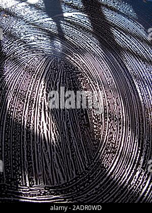 Volute del sapone in un modello circolare sulla tavola nera top Foto Stock
