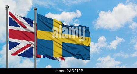 Regno Unito e Svezia bandiera sventolare nel vento contro bianco torbido cielo blu insieme. Concetto di Diplomazia e relazioni internazionali. Foto Stock