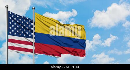 Negli Stati Uniti e in Colombia bandiera sventolare nel vento contro bianco torbido cielo blu insieme. Concetto di Diplomazia e relazioni internazionali. Foto Stock