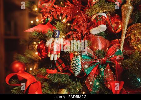 Soldatino schiaccianoci in legno statua in piedi di fronte ad albero di Natale decorato, in stile vintage Foto Stock