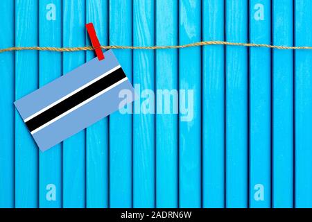 Bandiera del Botswana appesi stendibiancheria attaccato con clothespins in legno su aqua blu sullo sfondo di legno. Giornata nazionale del concetto. Foto Stock