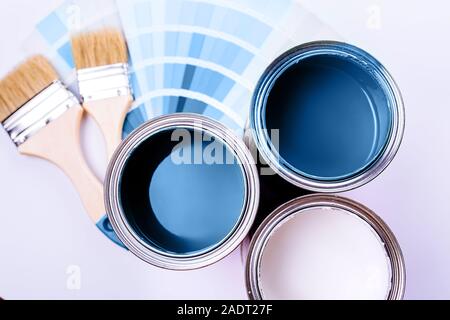 Spazzole e un aperto può con blu su un semplice sfondo grigio Foto Stock
