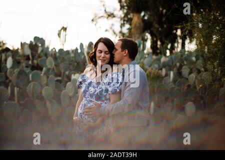 Il marito e la moglie incinta nel giardino di cactus Foto Stock