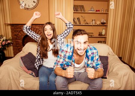 Emozionato amare giovane guardare i loro giochi preferiti sulla TV di casa Foto Stock