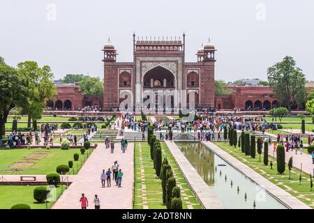 Grande entrata con cancello pedonale, piazza con giardino, piscina riflettente e visitatori presi dal Taj Mahal. Agra, Uttar Pradesh, India Foto Stock