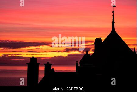 Lyme Regis, Dorset, Regno Unito. Il 5 dicembre 2019. Regno Unito: Meteo bella alba invernale a Lyme Regis. Gli edifici e gli alberi si stagliano contro bellissimi colori nel cielo su una fredda mattina. Credito: Celia McMahon/Alamy Live News. Foto Stock
