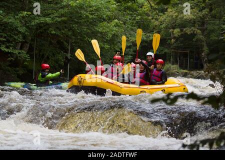 Acqua bianco rafters Shooting the Rapids presso il National White Water centro sul fiume Tryweryn nel Parco Nazionale di Snowdonia Foto Stock