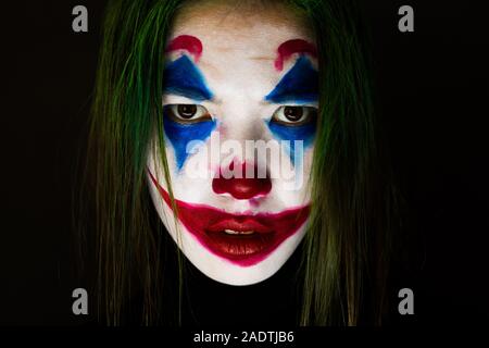 Il Kazakistan, KOSTANAY - Ottobre 21, 2019: Make-up Joker con i capelli verdi per la festa di Halloween. Close-up faccia su sfondo nero. Foto Stock