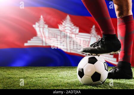 Chiudere le gambe della Cambogia football team player in rosso calzini, scarpe sul pallone da calcio al calcio di punizione o spot pena giocare sull'erba. Foto Stock