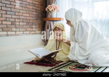 La madre e il bambino leggere il Corano Foto Stock