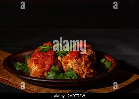 Deliziose polpette di carne macinata in piccante salsa di pomodoro servita su un piatto di argilla Foto Stock
