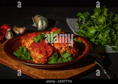 Deliziose polpette di carne macinata in piccante salsa di pomodoro servita su un piatto di argilla Foto Stock