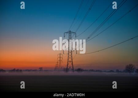 Tralicci di energia elettrica al tramonto sul livelli di Somerset Neil Phillips Foto e Film 4 Dicembre 2019 Foto Stock