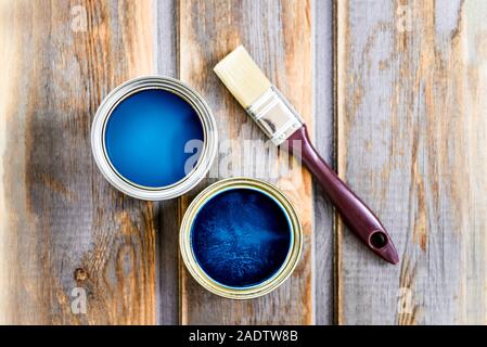 Preparazione per il restauro della scatola di legno con una spazzola e aprire le lattine di vernice blu Foto Stock