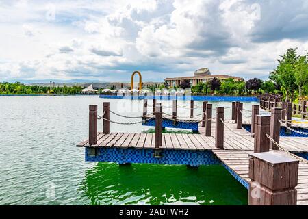 Dushanbe bandiera Polo Park pittoresca vista del lago e del Tagikistan Museo Nazionale in un nuvoloso cielo blu giorno Foto Stock