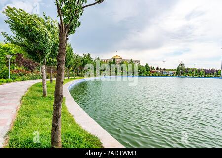 Dushanbe bandiera Polo pittoresco Parco Lago Vista del Palazzo delle Nazioni su un Nuvoloso Giorno di pioggia Foto Stock